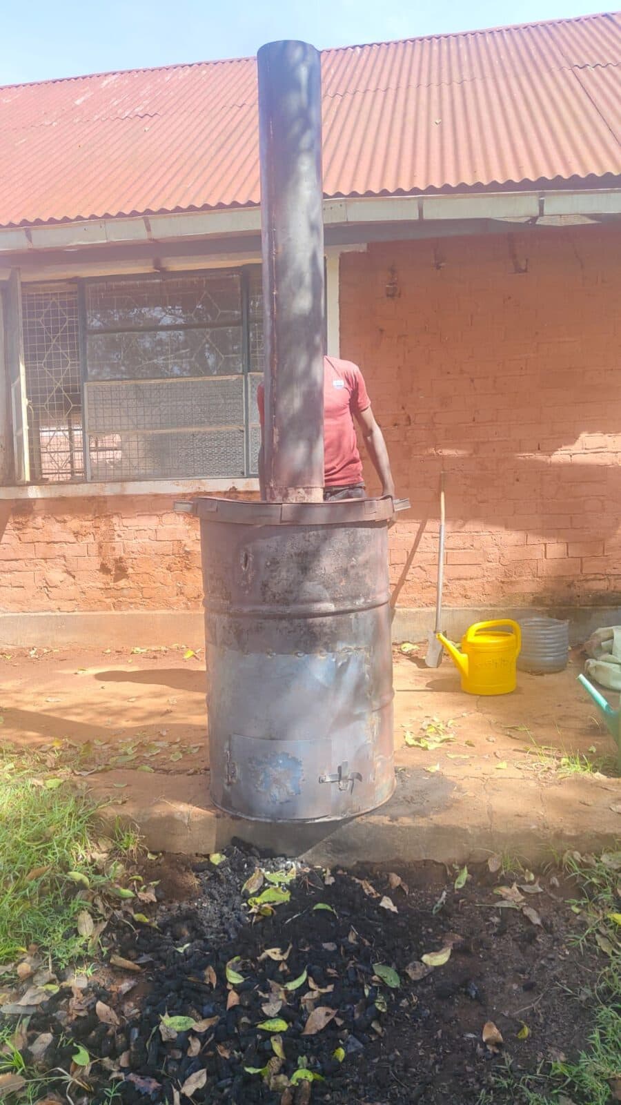 Drum kiln with a tall chimney being fitted at the biochar demonstration site