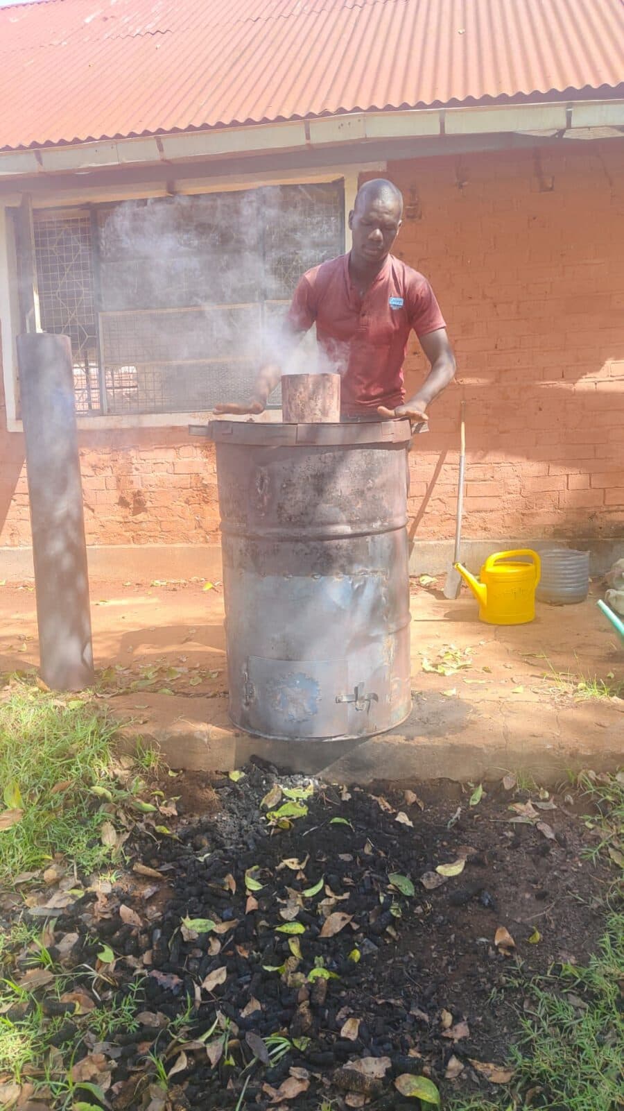 A trainer working at the top of the kiln as smoke begins to rise