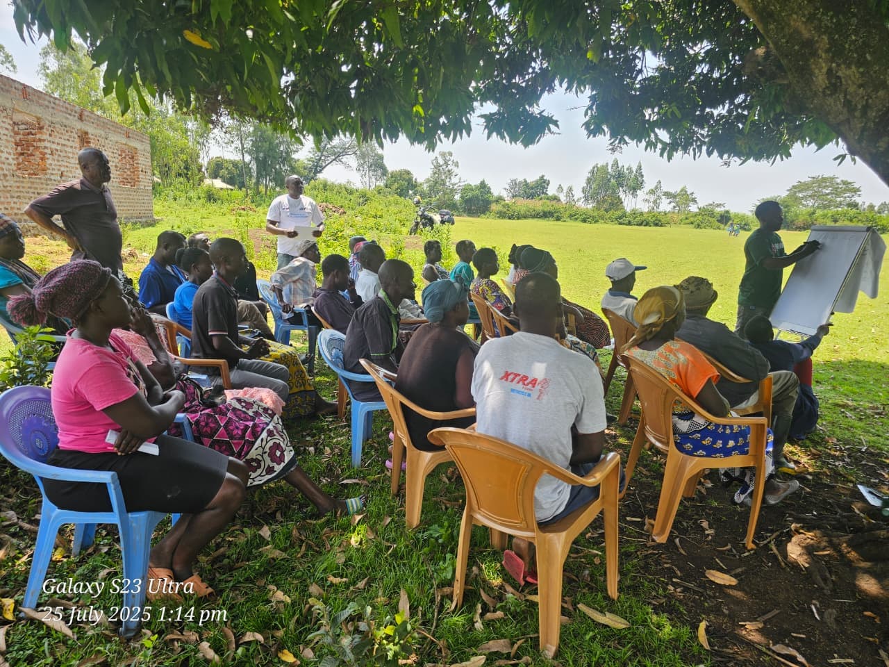 Agronomist demonstrating proper planting techniques to a group of attentive farmers